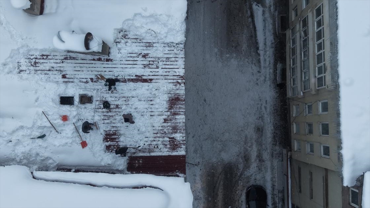 Muş’ta işçiler bellerine bağladıkları iple çatılarda kar temizliği yapıyor